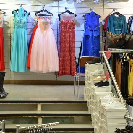 Elegante Kleider in Rot, Blau und Pastellfarben, dazu weiße Schuhe.