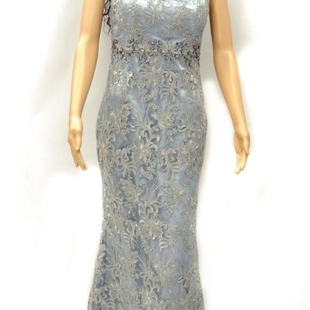 Figurbetontes Kleid mit Spitze auf einer Puppe.