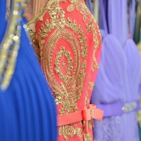 Korallfarbenes Kleid mit goldenen Mustern.