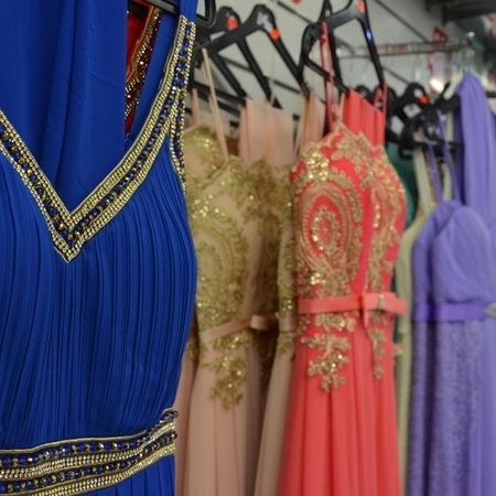 Abendkleider mit Schmuck im Hintergrund.