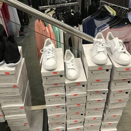 Sneakers im Regal – Mehrere Paare mit Preisschildern.